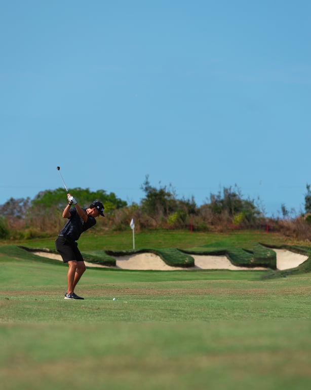 Golfer preparing to hit a ball on a sunny course